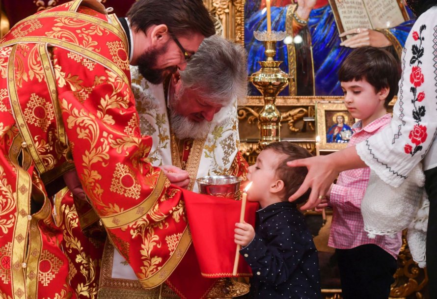 PS Varlaam Ploieșteanul împărtășind copii în Catedrala Patriarhală